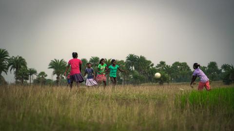 Children Playing Football in a Rural Field